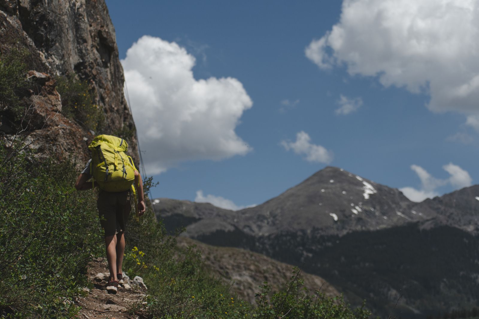 A backpacker taking the next steps along a mountain trail